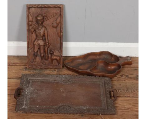 A collection of carved wooden items, including a panel depicting a hunting scene, a carved wooden tray, and a sculpted fruit 