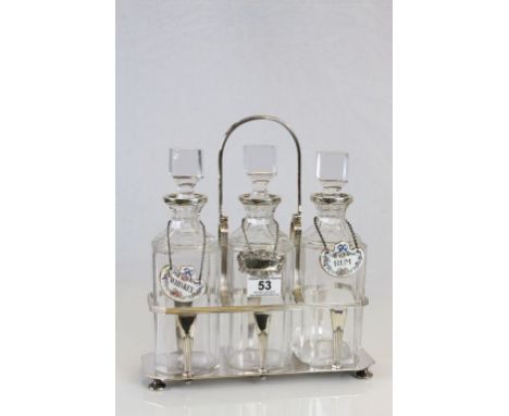 Silver plated three bottle Tantalus with original bottles, two with ceramic labels, the other with a Silver plated example