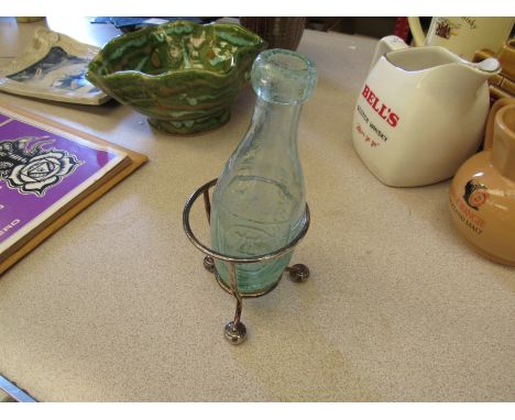 A vintage torpedo bottle in stand