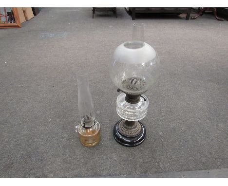 A Victorian oil lamp with etched globular shade and a hand-held oil lamp with star cut design