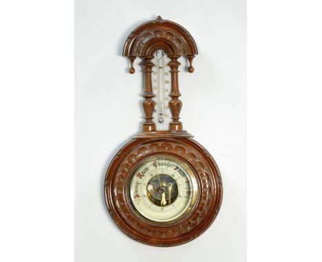 EDWARDIAN CARVED BLONDWOOD CASED ANEROID BAROMETER, with mercury thermometer to the trunk (a.f.), 13 1/2" (34.3cm) high  