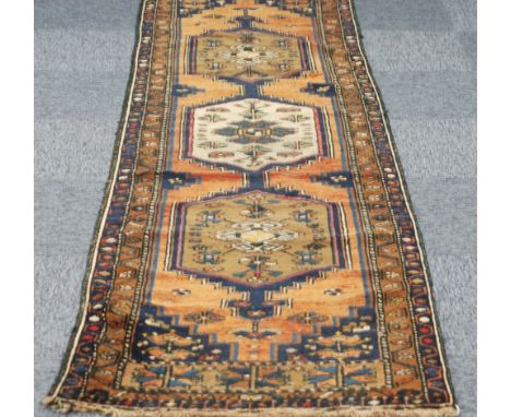 EASTERN RUNNER, with three large hexagonal pole medallions with stepped sides and arrow pattern and pendants on an old gold f