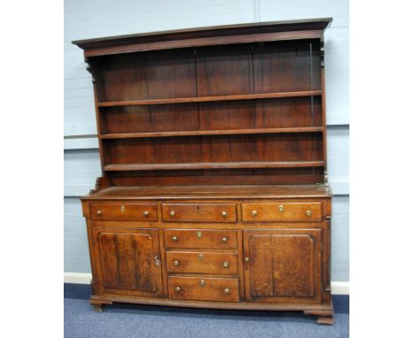 LATE EIGHTEENTH CENTURY OAK ENCLOSED DRESSER, the plate rack with moulded cornice and shaped sides, enclosing three shelves a