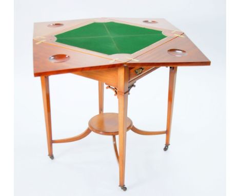 AN EDWARDIAN FADED MAHOGANY ENVELOPE FOLD OVER CARD TABLE,with frieze drawer, standing on square tapered legs, ending in pot 