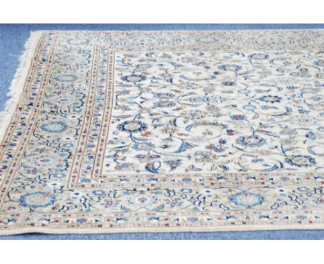 PERSIAN STYLE WOOL CARPET, with scrolling foliage containing palmettes and saz leaves worked in colours on an off-white field
