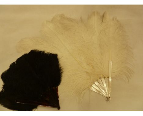 A mother of pearl ostrich feather fan described as a 'debutante's fan' with a black ostrich feather fan, tortoiseshell guards