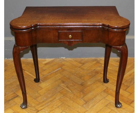 A mid 18th century, possibly Irish walnut games table, the beize lined fold over top with wells and corner stands over a frie