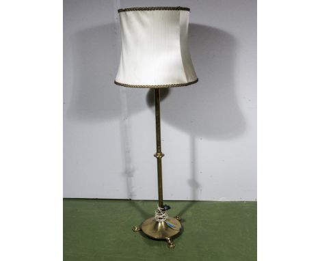 A brass Arts and Crafts style standard lamp and shade