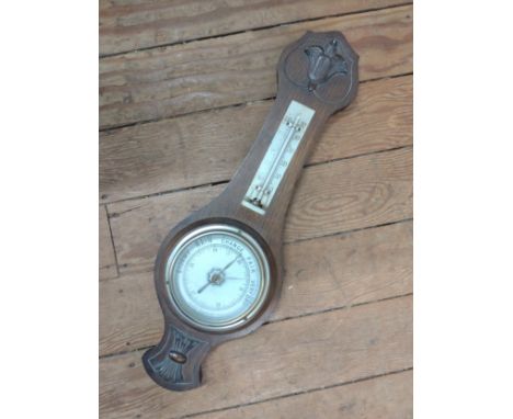 A Victorian Aneroid Barometer. Circa 1890. Of banjo form in a carved case. 