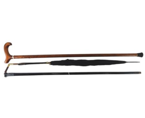 A Victorian ebonised walking cane, with silver mount, a walking stick with shaped handle, and an umbrella with gilt mounts. (