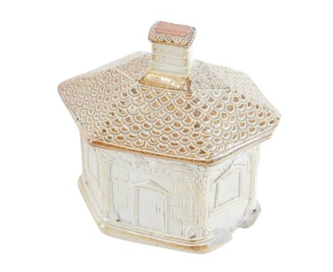 An early 19thC stoneware tobacco jar, modelled in the form of a cottage, the inner cover with dog knop, 15cm wide. (AF)