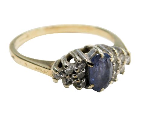 A 9ct gold sapphire and diamond ring, the oval cut sapphire flanked by six graduated diamonds to each side, in a basket setti