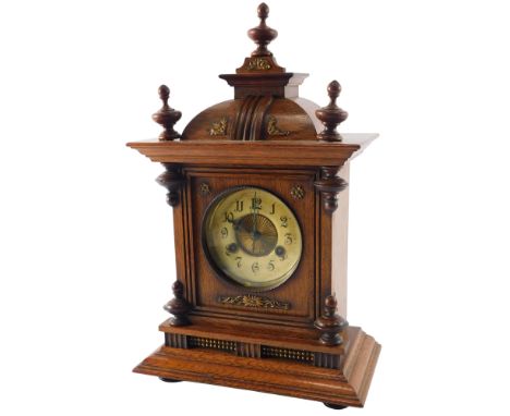 A late 19thC German mantel clock, in a walnut case, with turned finials, paper dial, etc., 44cm high.