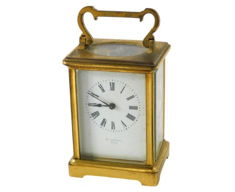 A French brass carriage time piece, the white enamel dial with Roman numerals, 15cm high.