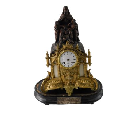 A 19thC French gilt and bronzed metal gothic style mantel clock, the case decorated with a figure, putti, and with white marb