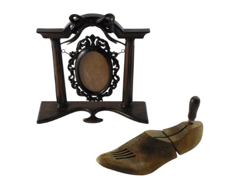 An elaborate 20thC photograph frame, with pillar supports, carved with a bow, 28cm high, and a coward comfort form shoe stret