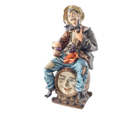 An unusual Capodimonte porcelain figure of a man with pipe, seated on a barrel of wine, stamped to underside, limited edition