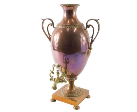 V A late 19thC brass and copper vase shaped two handled tea urn, on bun feet, 48cm high.