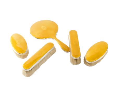 A George V silver mounted and gold coloured guilloche enamel dressing table set, comprising hand mirror, four brushes, Birmin