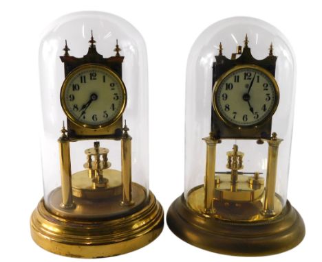 Two similar brass anniversary clocks, each with a white enamel dial, and a glass dome, 28cm high.
