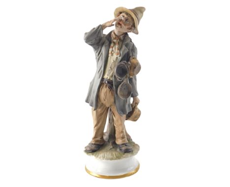 A Capodimonte porcelain figure of a man selling pans, on a circular base, 32cm high.