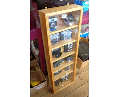 A collector's display case containing twelve assorted vintage cameras including Kodak Brownie Reflex 20, Roni Flex X3000, etc