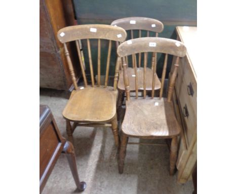 A pair of antique Windsor stick back kitchen chairs with solid moulded elm seats, set on ring turned supports - sold with ano