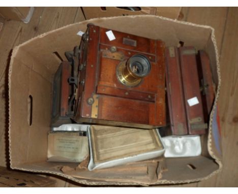 A box containing three antique box camera bodies and other old photographic items