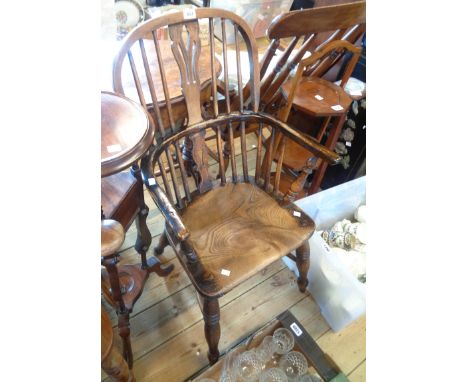 Windsor elbow chair An antique Windsor elbow chair with slender curved central rail and solid elm moulded seat, set on ring t