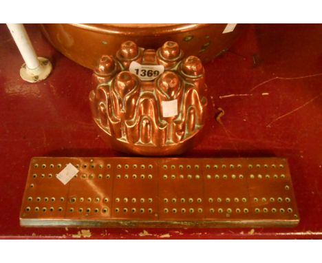 A Victorian copper jelly mould of castellated form with tinned interior - sold with a copper clad wooden cribbage board