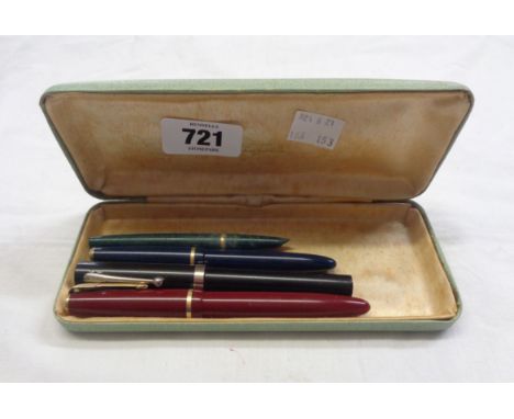 Four assorted vintage pens including a red Parker Duofold, a blue Parker Slimfold and two others