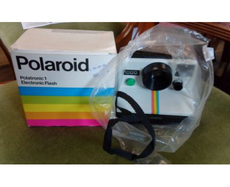 A vintage Polaroid 1000 land camera with instruction and boxed Polaroid flash