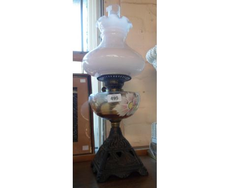 A late Victorian table oil lamp with enameled glass reservoir and cast iron base decorated with sailing ships - sold with lat