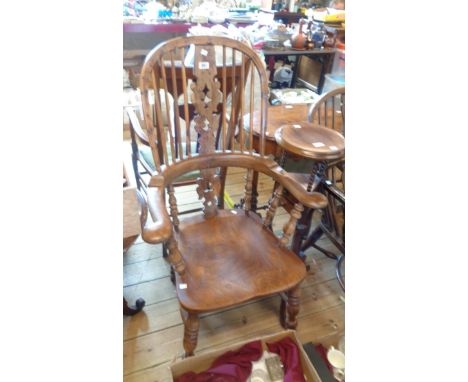 An antique yew and elm Windsor hoop stick back elbow chair with pierced splat and solid elm moulded seat, set on turned suppo