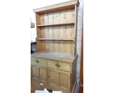 A 1.15cm old stripped pine two part dresser with two shelf open plate rack over a base with two frieze drawers and double cup