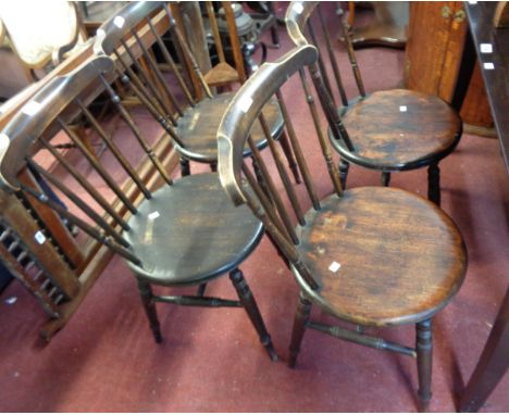 A set of four late 19th Century continental stained wood stick back chairs with circular seat panels, set on ring turned legs