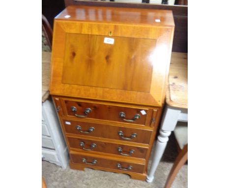 A 51cm modern yew effect bureau with part fitted interior and four long drawers under, set bracket feet