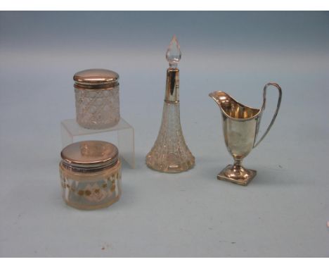 A Jubilee silver helmet-shape cream jug, 1977, together with two silver-mounted glass dressing bottles and a silver-mounted c