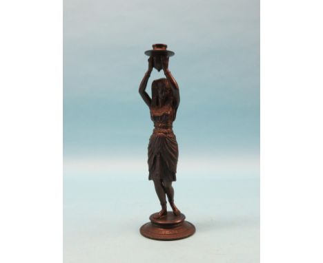 A bronzed spelter candlestick figure, Egyptian female holding sconce aloft, circular base, 15in. 