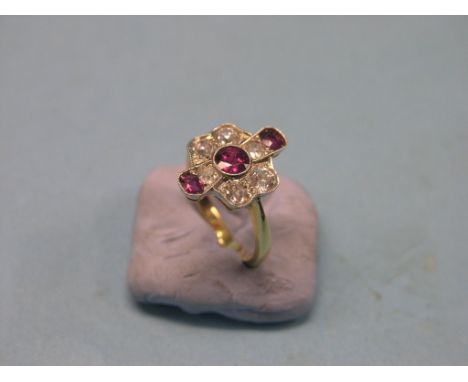 A large ruby and diamond dress ring, three rubies, six diamonds, 18ct. gold shank, size O