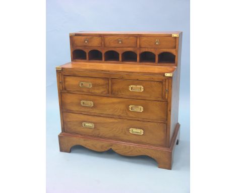 A reproduction light elm writing cabinet, three raised drawers above open recesses, folding writing surface above two short a