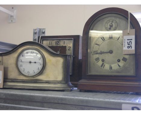 A domed mantel clock, with arched, silvered dial, French movement striking three gongs, with key and pendulum, 10in. high, an