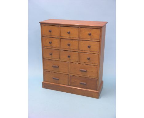 A light-stained pine storage chest, nine short and four long drawers, wood handles, 2ft. 5in. 
