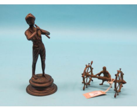 A cast brass model of an artisan, at mill-work with operating spoked wheels, 3.5in. high and a bronzed metal figure of a male