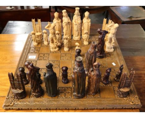Heavily carved chess set on wooden base with foliate decoration, resin figures of kings and queens etc. (B.P. 24% incl. VAT) 