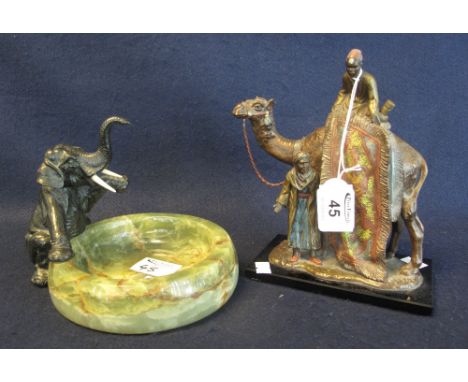 A spelter table lighter in the form of a camel with Arabian figures in the style of Bergmann, together with an onyx ashtray w