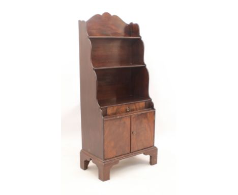 A small mahogany waterfall bookcase in Georgian style - mid-20th century, the shaped back above a single drawer and two-door 