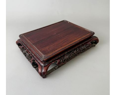 An antique Chinese carved hardwood vase or jade stand - rectangular with a pierced convex frieze carved with prunus flowers a