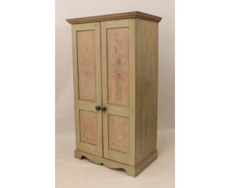 A painted wardrobe of small proportions - the moulded top over two doors painted with stencilled floral and foliate decoratio