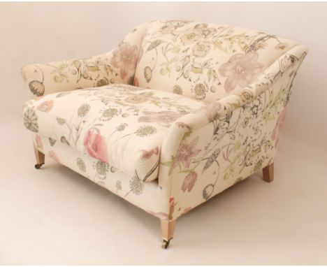 A small sofa or love seat by Lorfords - maker's label stitched to underside, upholstered in floral printed cream fabric, rais